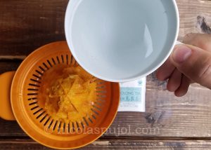 Pour hot water over the orange juice pulp