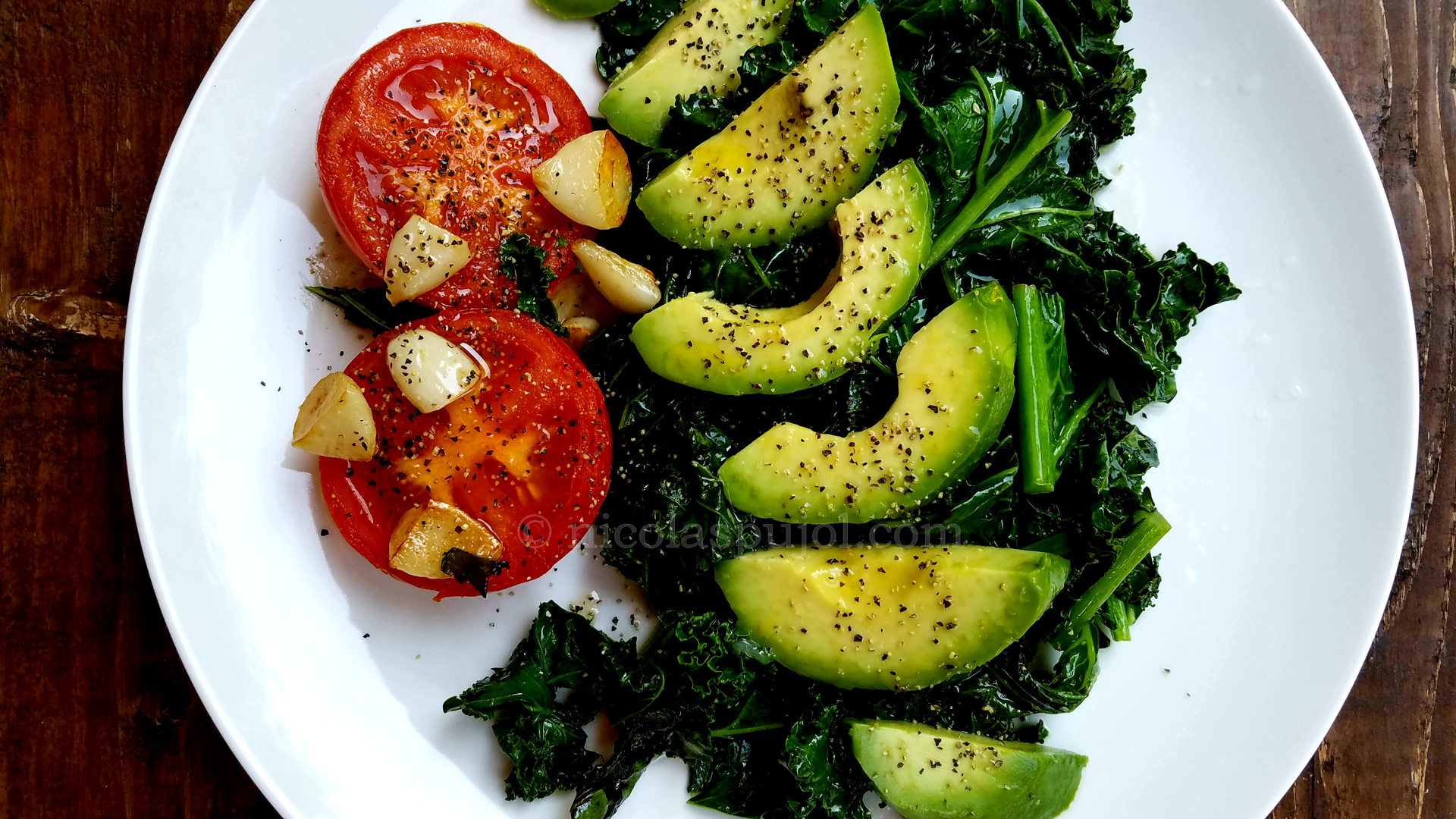 Seared kale and tomato with avocado olive oil and lemon