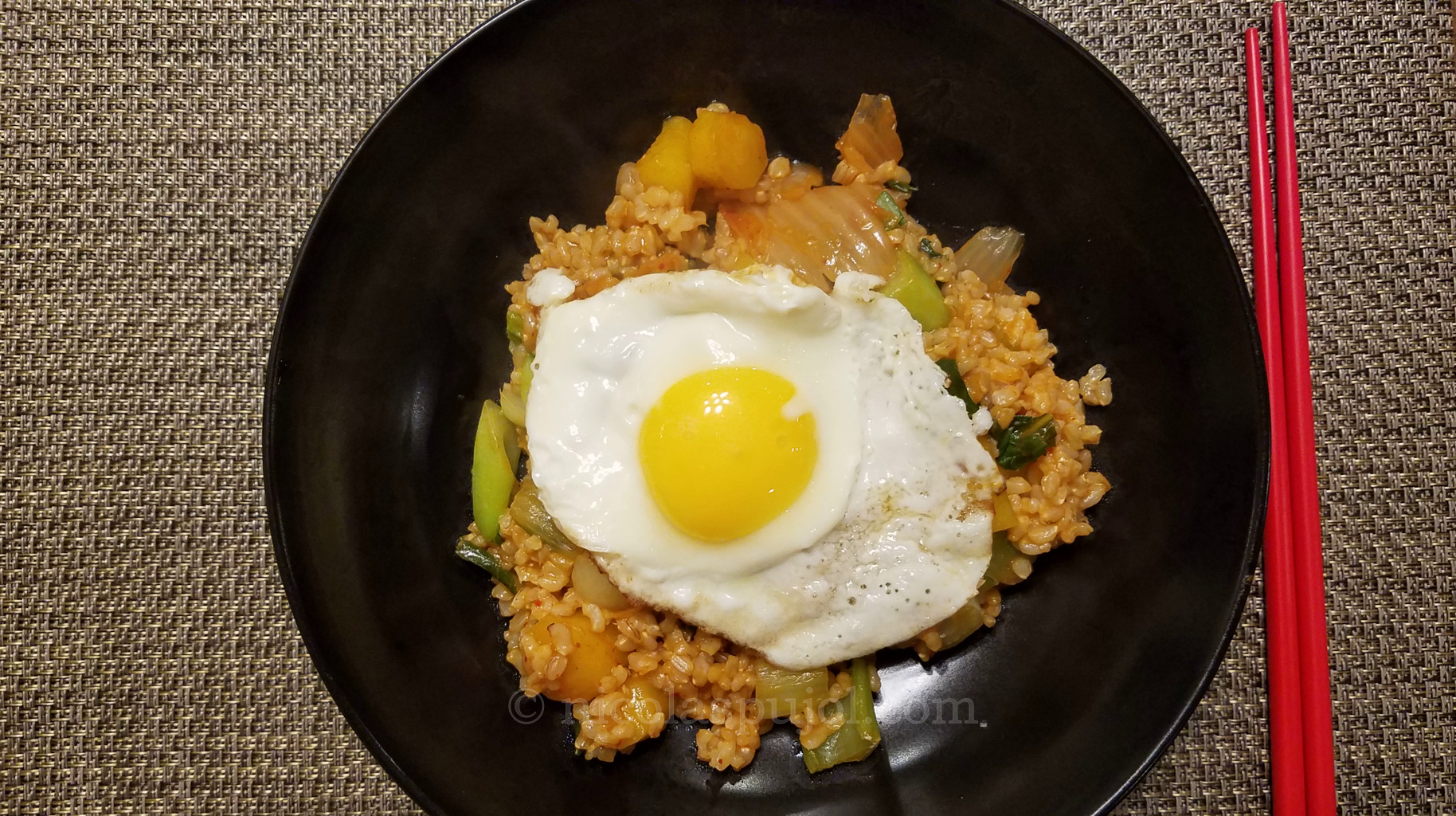 A plate of kimchi brown rice stir fry with an egg