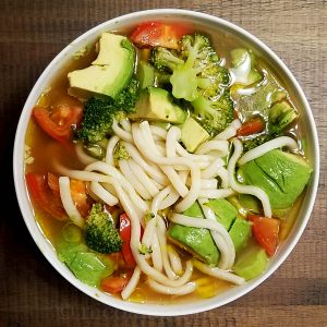 Udon noodle soup with avocados tomato, broccoli, olive oil