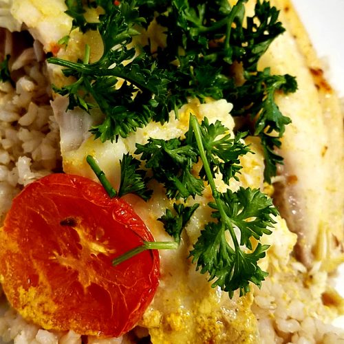 Presentation serving for baked tilapia with coconut milk, tomato and parsley