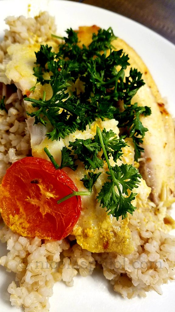 Presentation serving for oven baked tilapia in coconut milk, tomato and parsley