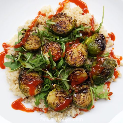 Baked Brussels sprouts on arugula, brown rice and balsamic vinegar