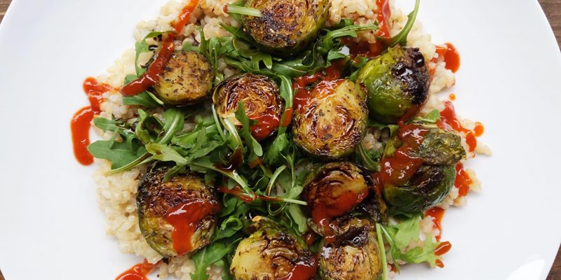 Baked Brussels sprouts on arugula, brown rice and balsamic vinegar