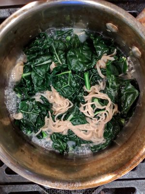 Lightly boiling the kale in the noodle water