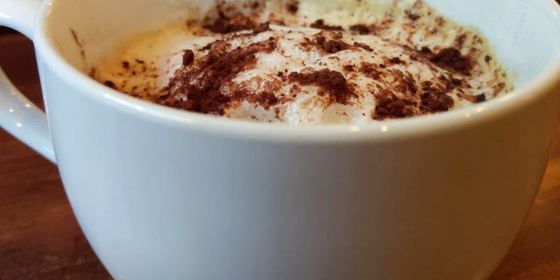 Vegan cappuccino coffee with unsweetened cocoa powder