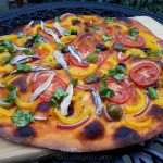 Spanish brava sauce pizza with vegetables and side of anchovies