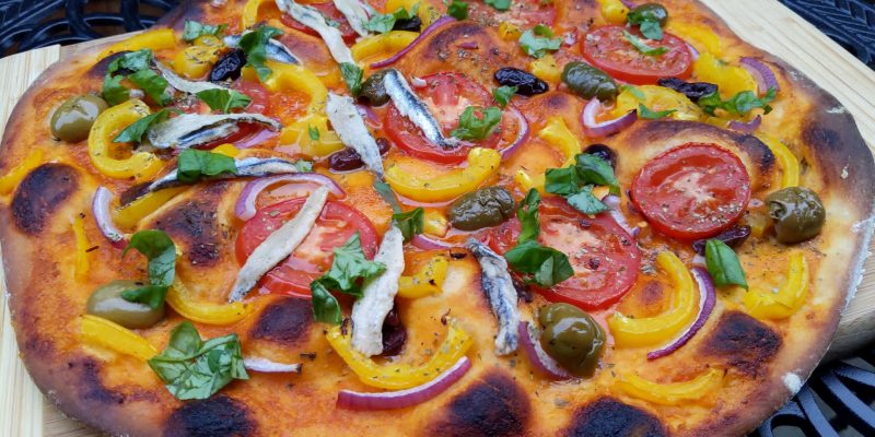 Spanish brava sauce pizza with vegetables and side of anchovies